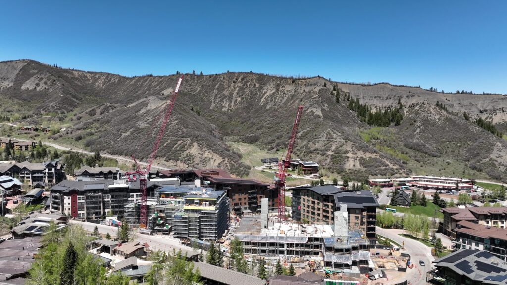 A north-facing view of Stratos framed by the surrounding Snowmass landscape, with the Rim Trail visible winding across the hillside in the background.